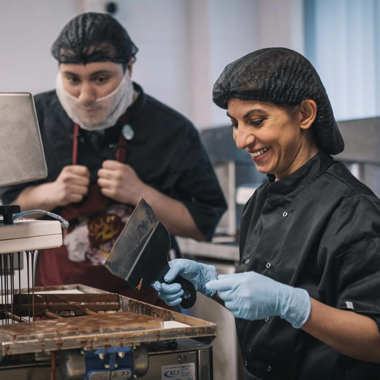 Mona Shah hand-finishing chocolates in the Ely workshop with a colleague